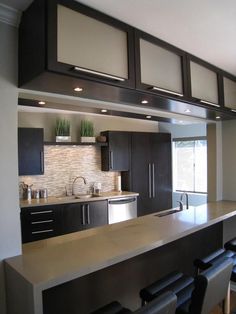 a modern kitchen with stainless steel appliances and bar stools