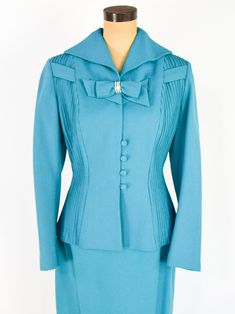 "~ 1950s Gorgeous turquoise blue wool crepe suit ~ This beautiful suit was my Mother's and only worn a few times. ~ Remembering Mom fondly as I'm finally ready to let the suit go ~ Matching decorative bow with rhinestones ~ Both front sides have sewn down pleats ~ Interesting collar & fitted waist ~ 4 covered buttons ~ Jacket has blue silk crepe lining ~ Skirt is half lined in taffeta ~ 7\" side metal zipper ~ Excellent Label: Lilli Ann, Luxurious Fabric of Paris, Loomed in Paris Jacket Bust Luxury Light Blue Top With Button Closure, Blue Vintage Blazer With Lapel Collar, Vintage Blue Outerwear With Snap Buttons, Vintage Blue Notch Lapel Outerwear, Vintage Blue Blazer With Button Closure, Layered Ruffle Dress, Lilli Ann, Remembering Mom, Wool Crepe