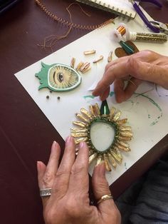 an older woman is working on something with gold and green decorations in the shape of sunflowers