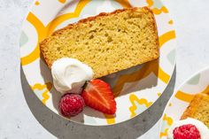 two slices of pound cake with whipped cream and strawberries on the plate next to it