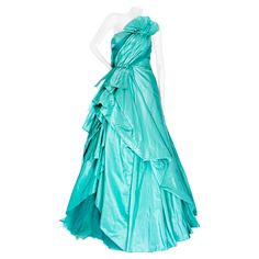 Oscar de la Renta 2013 Turquoise Blue Taffeta and Tulle Strapless Gown Resort Collection at Moda Nextel (Mexico) Aqua Blue / Turquoise One shoulder Ruched bodice Fan detail Side draping with inset tulle Gathered back Pointed train Tulle lining Boned bustier Back zipper closure Made in USA 100% silk Very good preowned unworn condition; side draping detached in a couple areas and some broken stitches on bodice Size & Measurements Approximate, taken flat: US 8 May run small; please refer to measurements Bust: 14.5" Waist: 13.5" Back Center Length: 56" Mannequin is an approximate US Size 4; garment was clipped for photos. Strapless Gown, Ruched Bodice, Bleu Turquoise, Resort Collection, Blue Turquoise, Aqua Blue, Turquoise Blue, Bodice, Evening Dresses