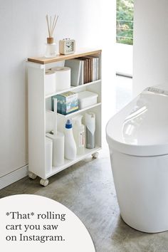 White rolling storage cart holding cleaning products, toilet paper, hygiene items, books, and decor in the bathroom by Yamazaki Home. Bathroom Cart, Rolling Storage Cart, Rolling Storage, Bathroom Items, Storage Cart, Minimalist Bathroom, Storage Hacks, Bathroom Essentials, Bathroom Organization