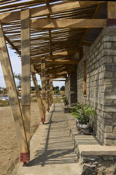 an outdoor covered walkway with potted plants on each side