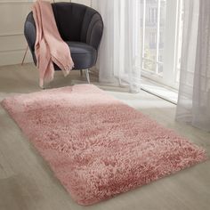 a living room with a chair, rug and window