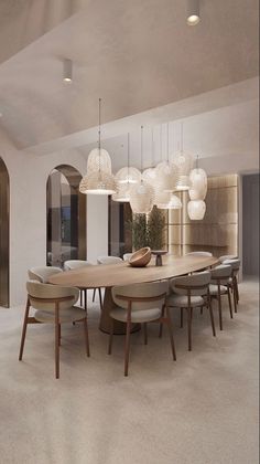 a dining room table surrounded by white chairs and round lights hanging from the ceiling above it