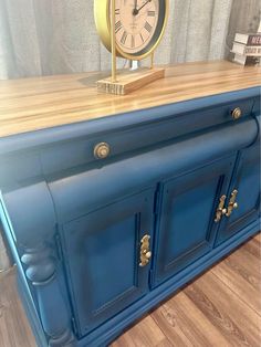 a blue dresser with a clock on top