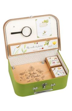 an open green suitcase with four coasters and a magnifying glass in it