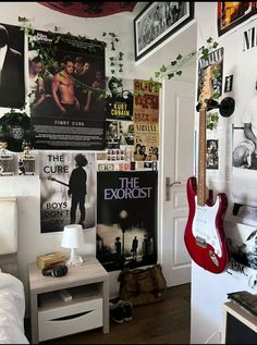 a bedroom with posters and guitars on the wall