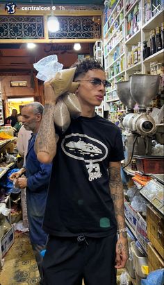 a man with tattoos is carrying something on his shoulder in a store filled with other items