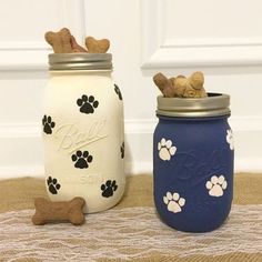 two mason jars with dog paw prints on them, one blue and the other white