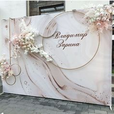 a large sign with flowers on it in front of a building