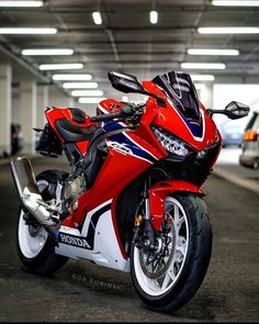 a red motorcycle parked in a parking garage