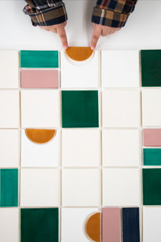 a person standing on top of a tiled floor next to a white and green wall