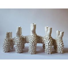 five white vases are stacked on top of each other with holes in the middle