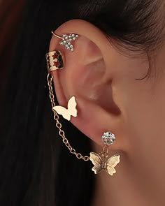 a close up of a person's ear with two butterflies attached to the ear