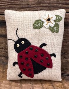 a decorative pillow with a ladybug on it