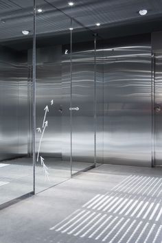 an empty room with glass partitions and white lines on the wall, in front of it