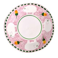 a pink plate with green trim and white sheeps on it, surrounded by carrots