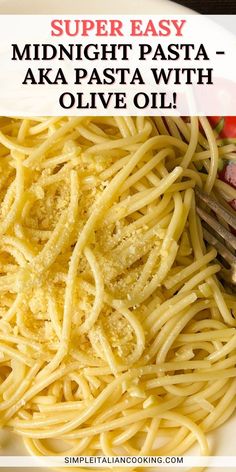 a white plate topped with pasta and cheese next to a fork on top of it