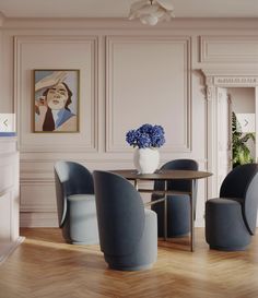 an elegant dining room with blue chairs and a round table in front of a fireplace