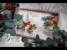 two red birds sitting on top of a wooden frame next to greenery and berries