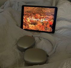 a tablet sitting on top of a bed next to two foot stools in front of it