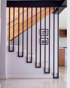 a stair case with pictures on the wall next to it