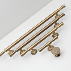 four brass handles and knobs on a white surface