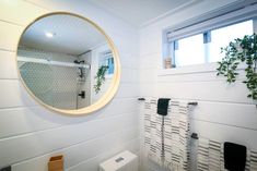 a bathroom with a round mirror on the wall