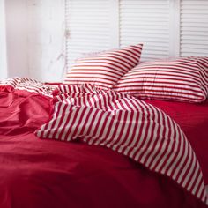 red and white striped bedding in a bedroom with shutters on the window sill