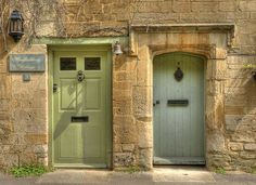 two green doors on an old stone building