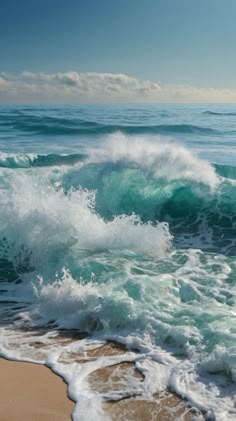 the ocean waves are crashing on the beach sand and blue sky with clouds in the background