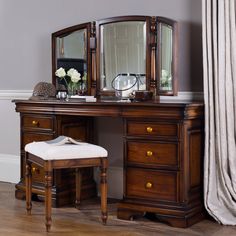 a wooden desk with a mirror and stool