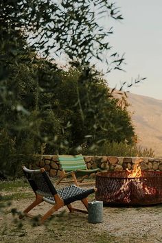 two chairs sitting next to an outdoor fire pit