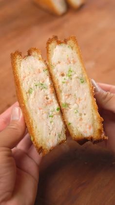 two pieces of bread with meat and veggies on it being held by someone's hand