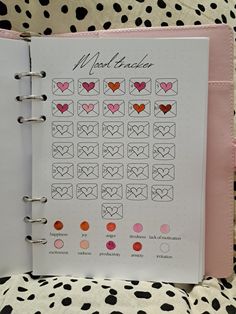 an open planner with hearts on it sitting on top of a polka dot print blanket