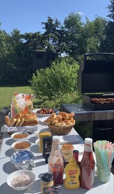 an outdoor bbq grill with food and drinks on the outside table in front of it