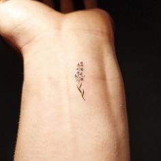 a small flower tattoo on the wrist