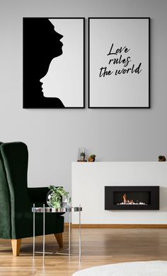 two black and white posters hanging on the wall next to a green chair in front of a fireplace