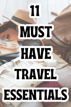 the words 11 must have travel essentials on top of an open suitcase with clothes and other items