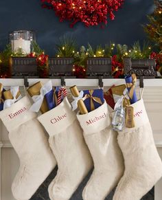 christmas stockings hanging from a mantel with candles and decorations on the mantle above them