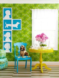 a small dog sitting in a blue chair next to a table with flowers on it