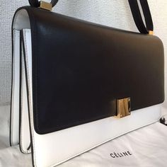 a black and white purse sitting on top of a bed