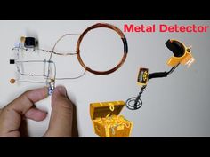 a hand is holding a wire and some other electrical equipment on a table with the words metal detector above it