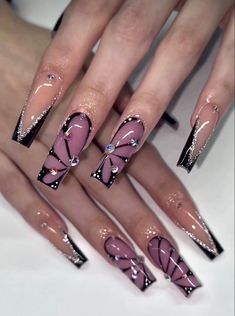 a woman's nails with pink and black designs on them