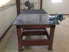 a table sawing machine sitting on top of a piece of wood in a garage