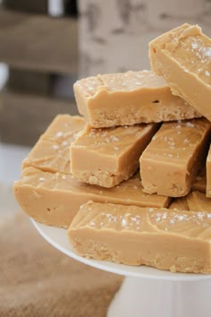 several pieces of peanut butter fudge on a white cake plate