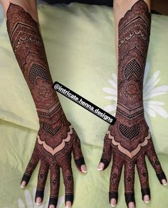 two hands with henna tattoos on them