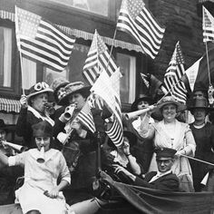 an old black and white photo of many people in a boat with american flags on it