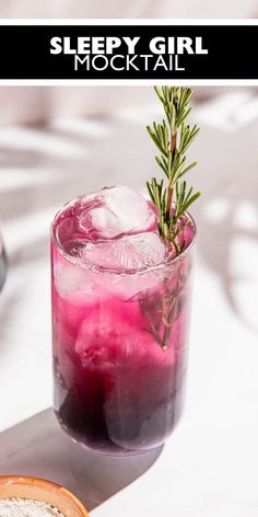 a drink with ice and rosemary garnish sitting on a table next to a slice of bread